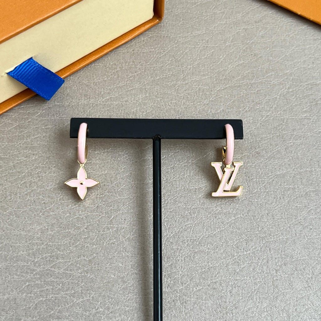 Gold-tone and pink charm earrings on dark stand, with Louis Vuitton logo details