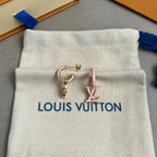 Cream fabric drawstring pouch with blue cord and Louis Vuitton logo, showing gold hoop earring