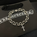 Silver-tone chain bracelet with round links and hanging cross charm