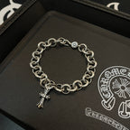 Silver-tone chain bracelet with circular links and hanging cross charm