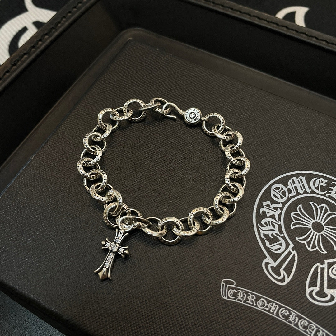 Silver-tone chain bracelet with circular links and hanging cross charm