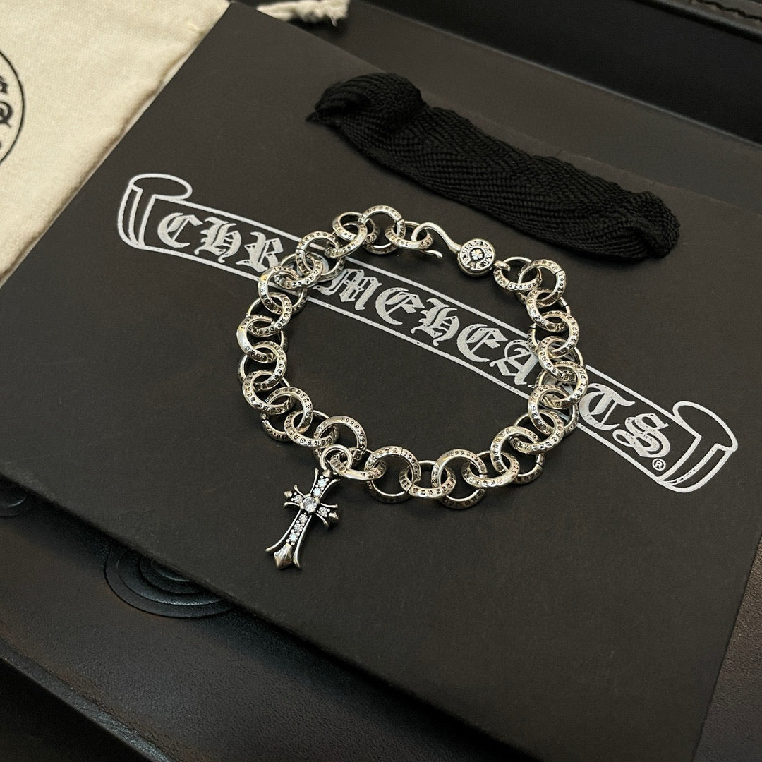 Silver-tone round-link chain bracelet with small cross charm at center