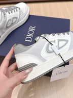 White Dior lace-up sneaker with gray laces and side emblem, on navy box