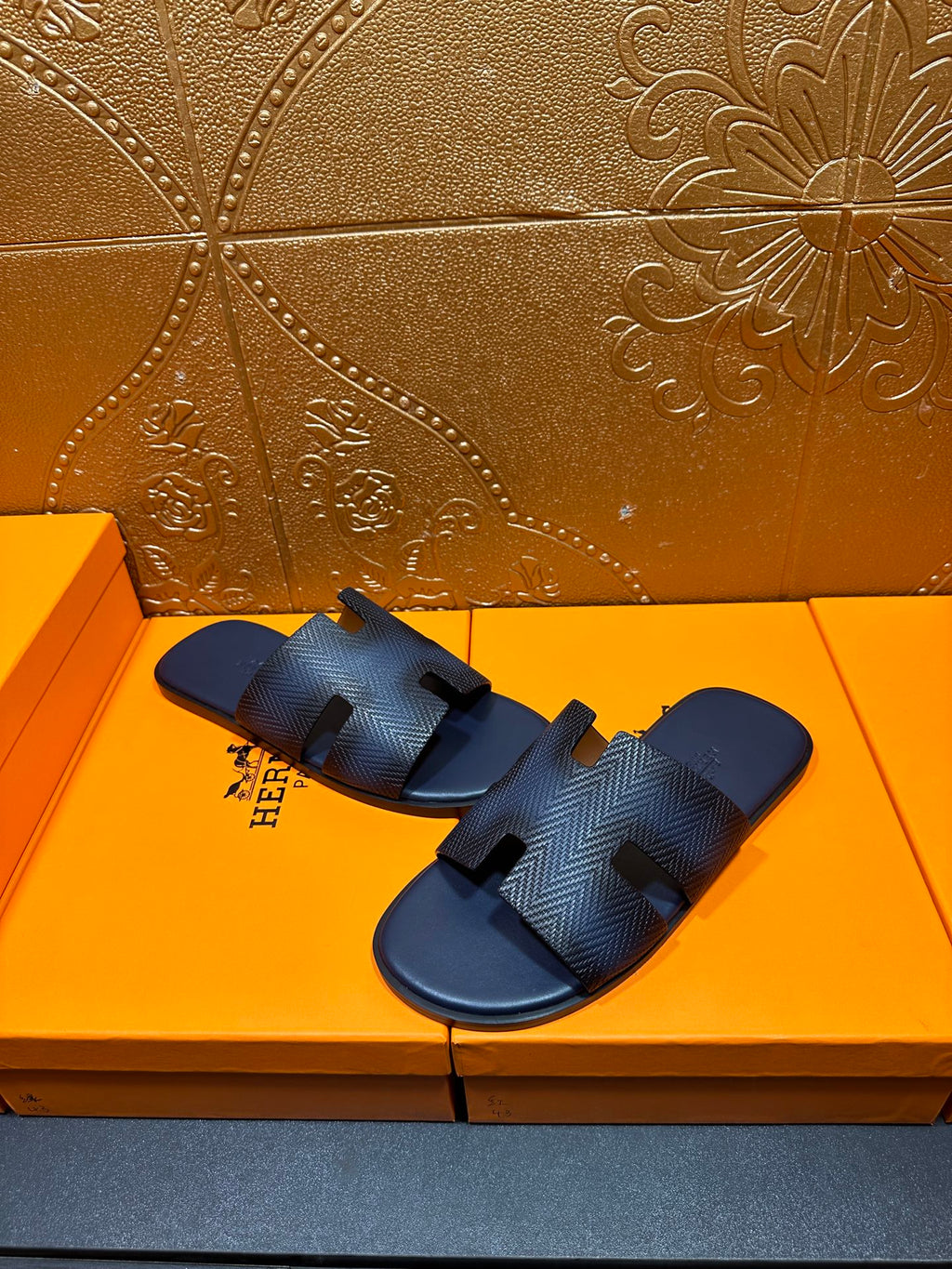 Dark blue textured slide sandals with open toe and cutout H strap design