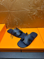 Dark blue textured slide sandals with open toe and cutout H strap design