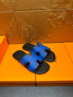 Hermes blue slide sandals with black footbed and H cutout strap, side view