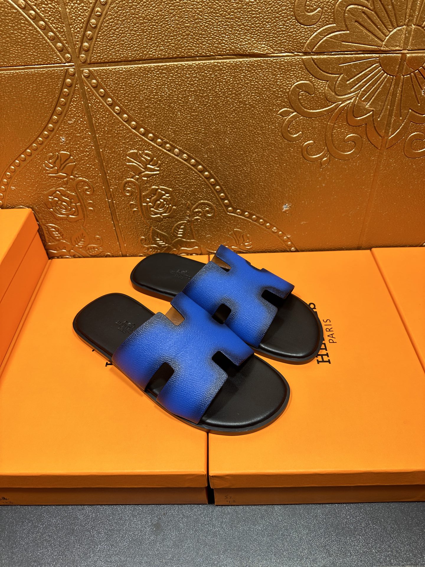 Hermes blue slide sandals with black footbed and H cutout strap, side view