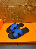 Hermes blue slide sandals on black footbed, H cutout strap detail