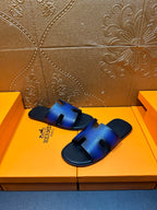 Blue leather slide sandals showing toe cutout and textured footbed