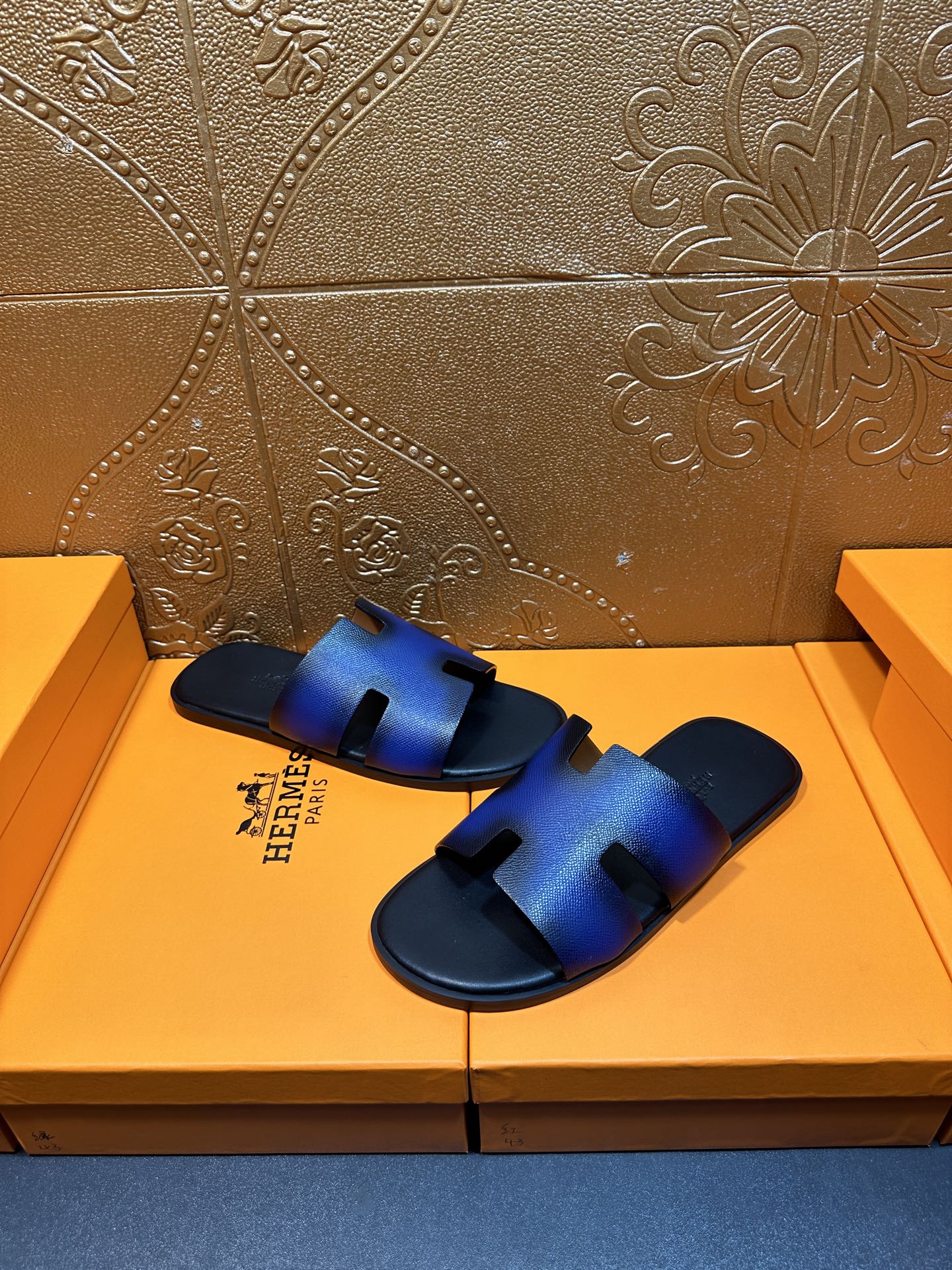 Blue leather slide sandals showing toe cutout and textured footbed