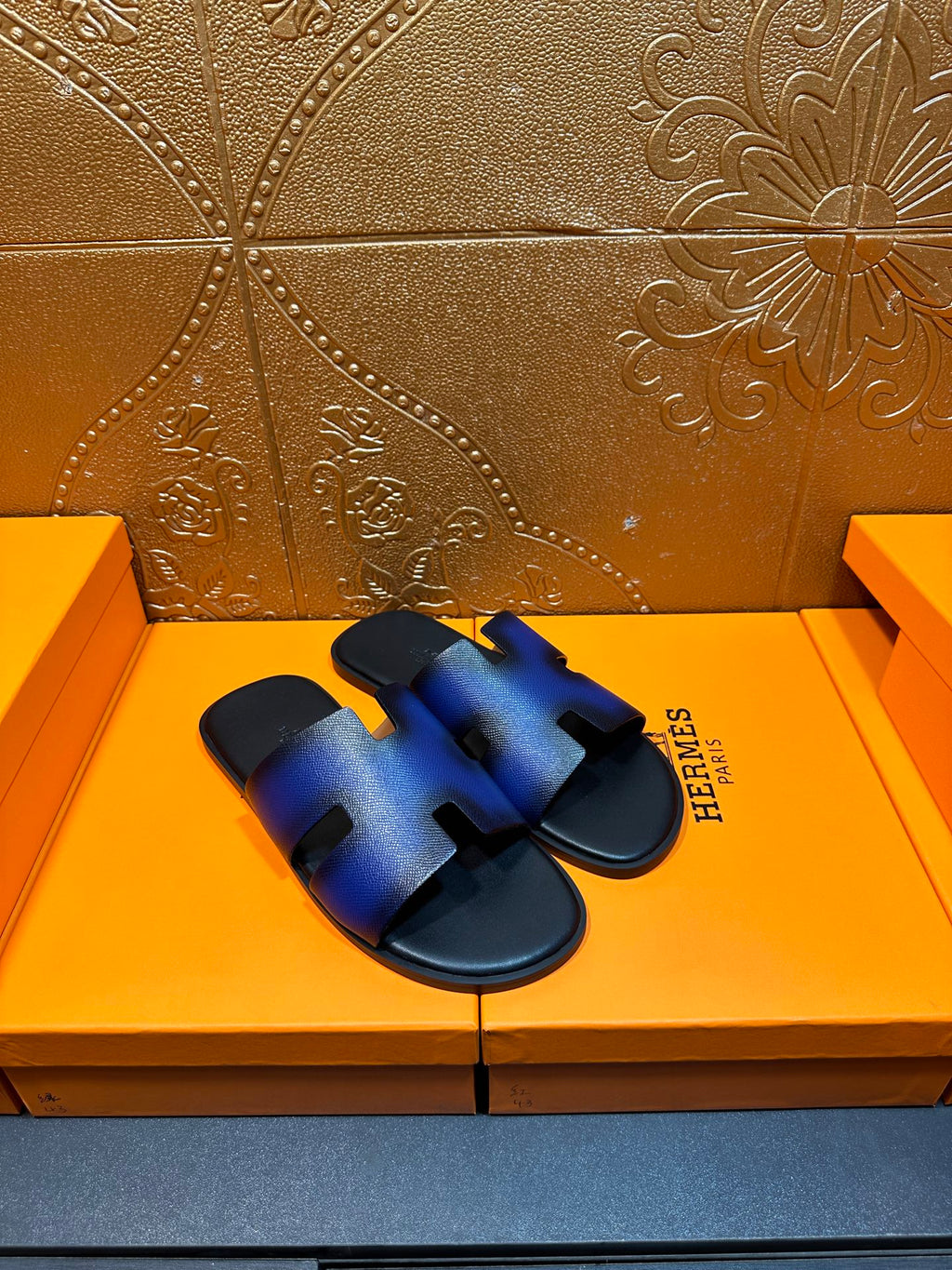 Blue leather slide sandals with four cutout openings and black slip-on sole