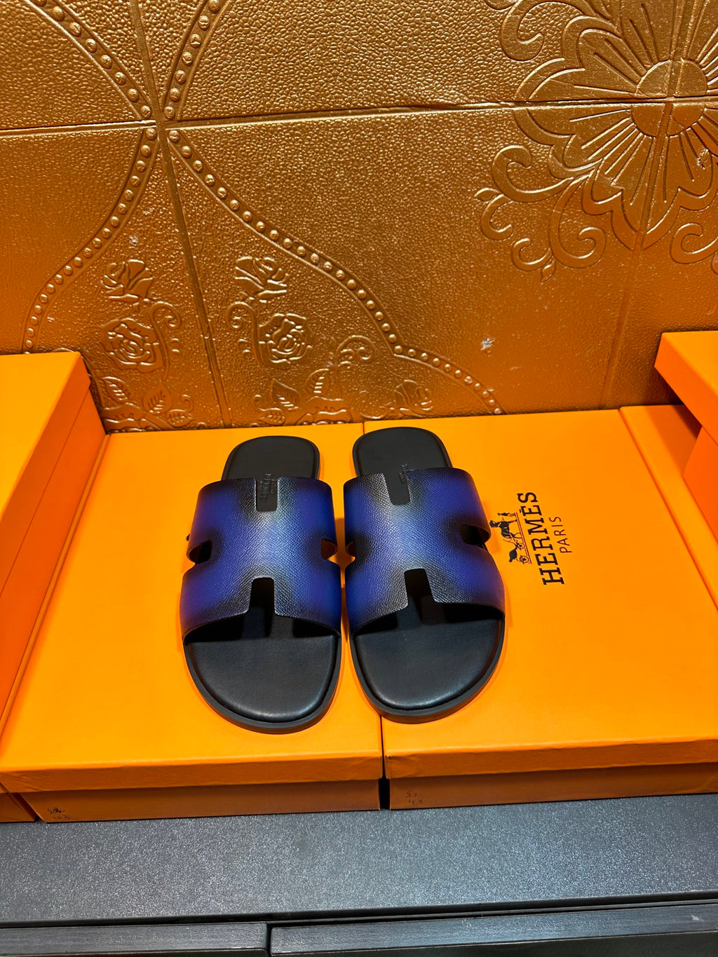 Blue and black leather slide sandals with cutout strap and flat rubber sole