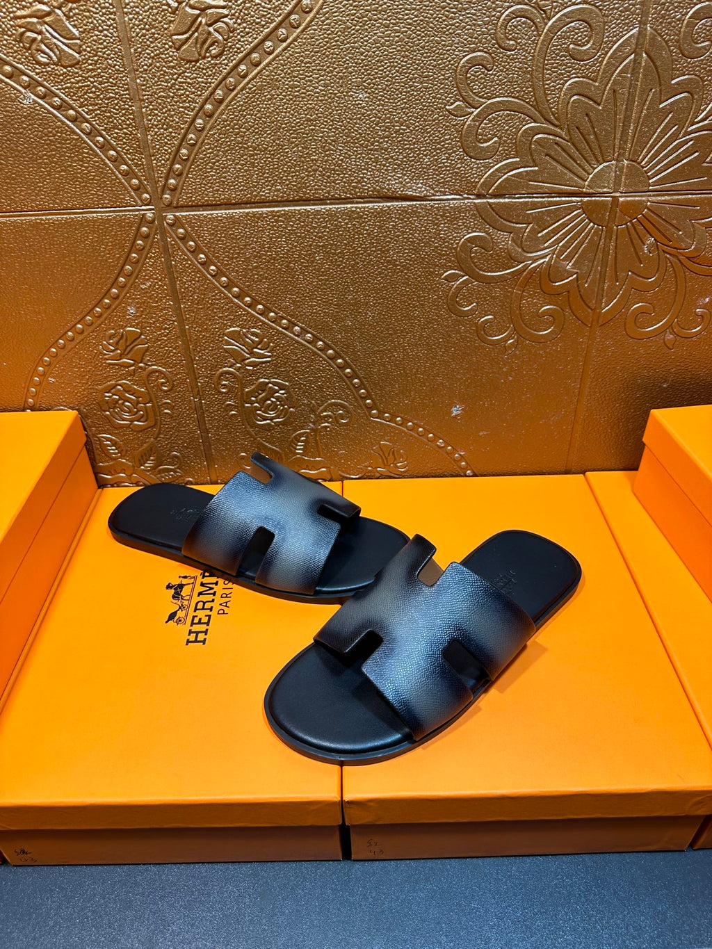 Leather slide sandals with textured finish, wide straps, and HERMES logo, dark blue.