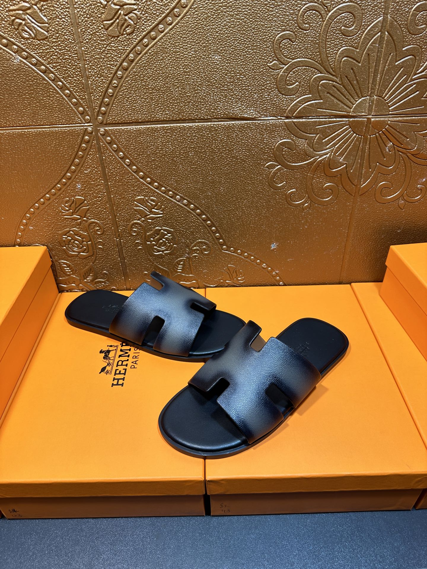 Leather slide sandals with textured finish, wide straps, and HERMES logo, dark blue.