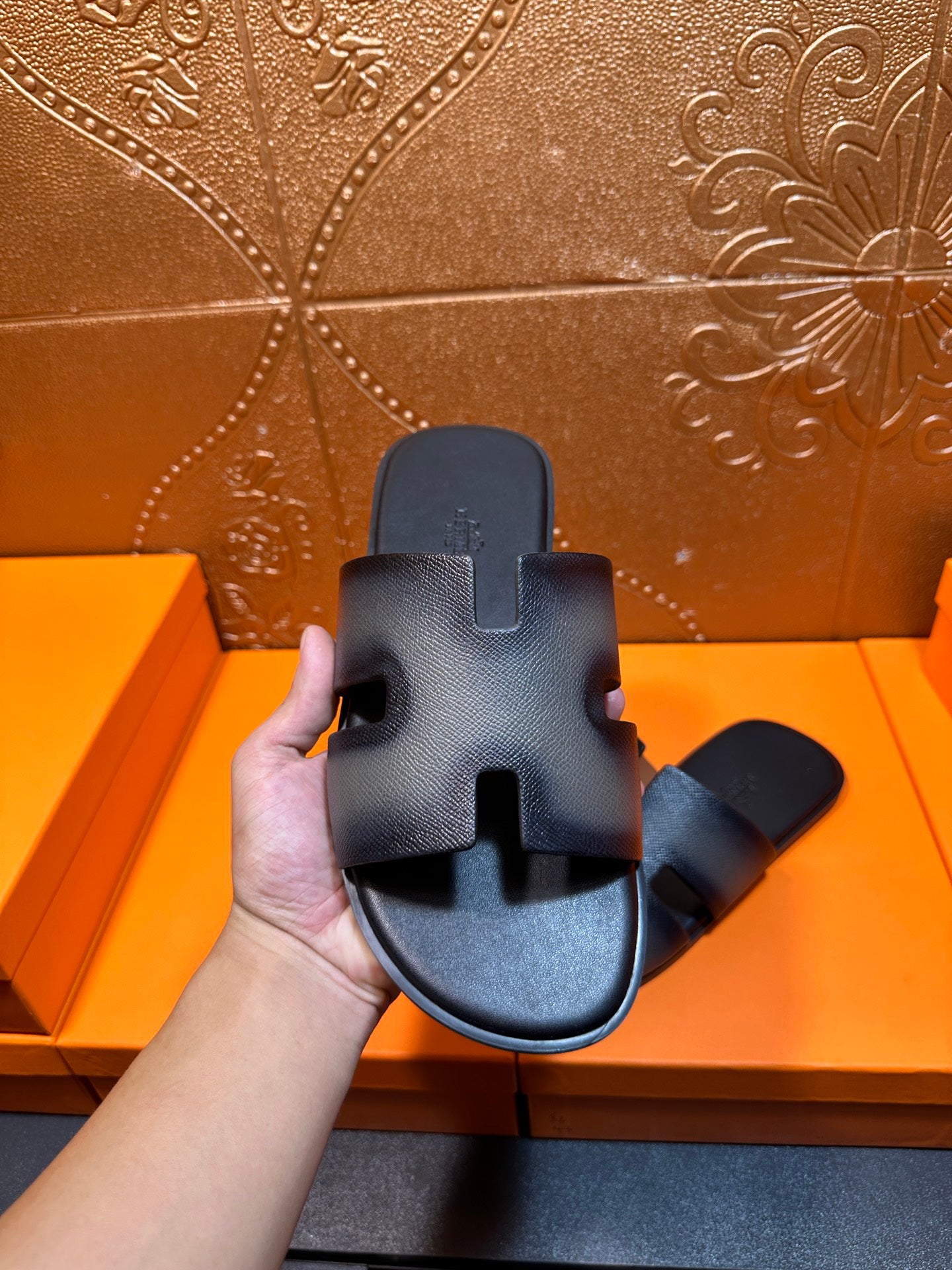 Dark blue leather slide sandals shown front view with wide strap cutouts.