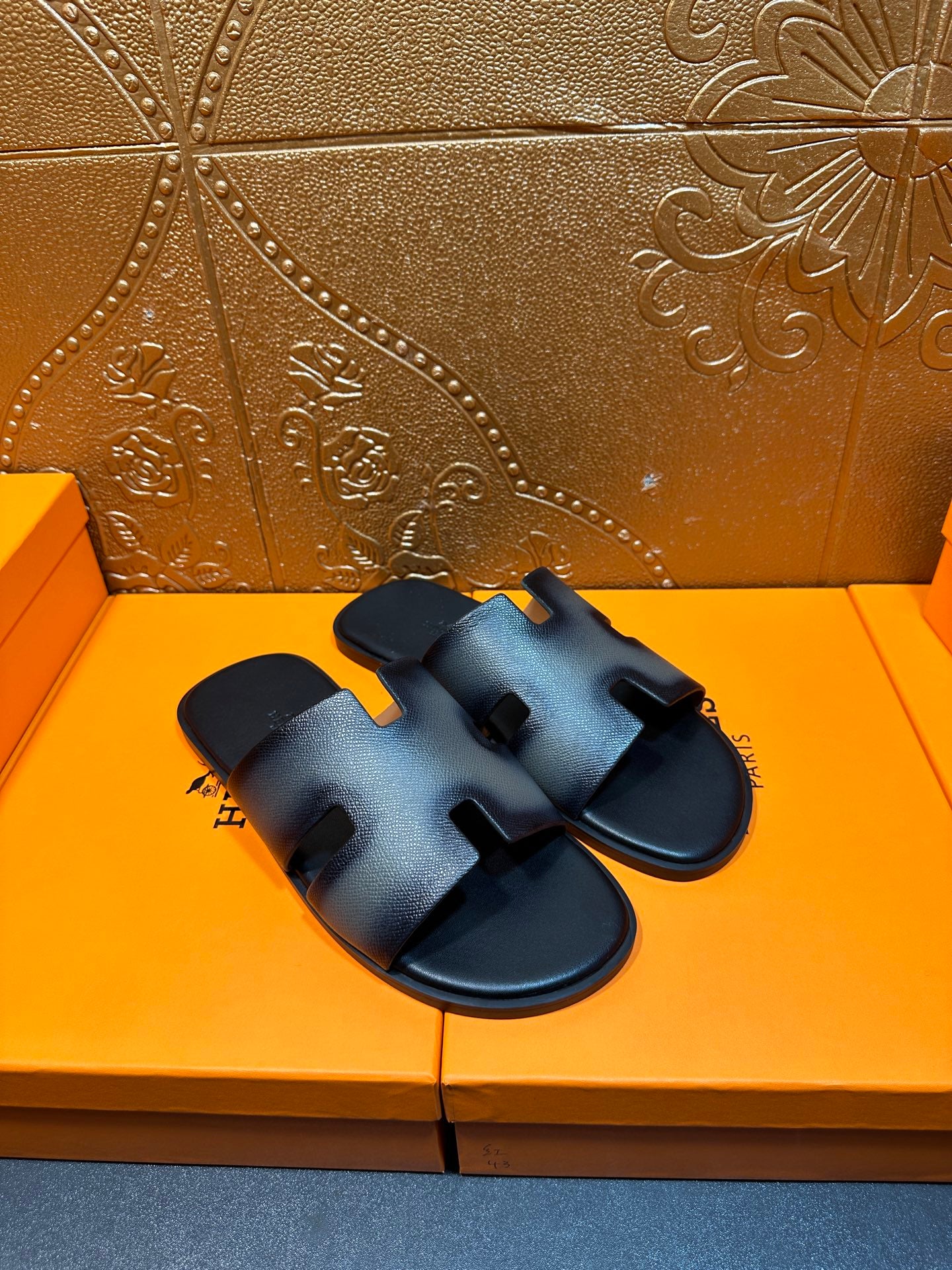 Pair of dark blue leather slide sandals with sculpted footbed and logo strap.