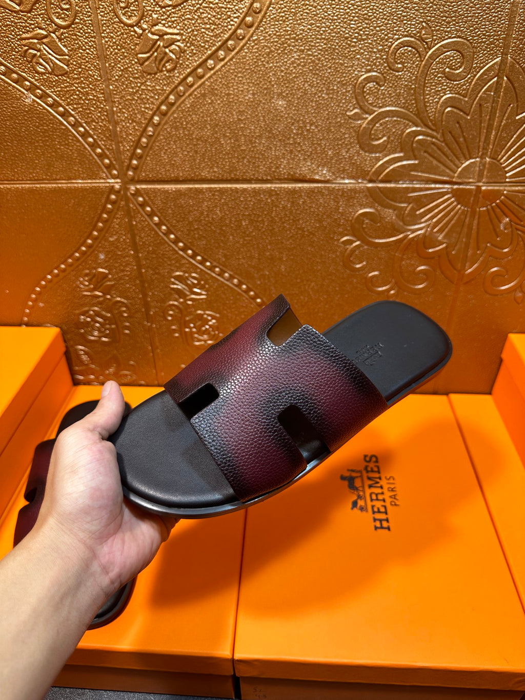 Hermes slide sandals, side view with H cutout straps on dark textured leather
