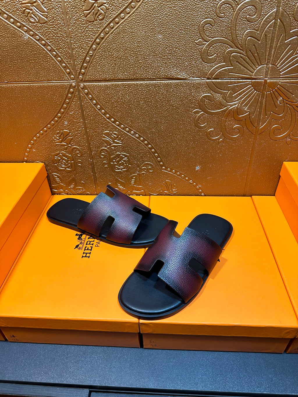 Hermes slide sandals, front view with H cutout straps, dark textured leather