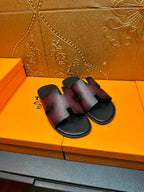 Hermes slide sandals, angled pair view, H cutout straps on dark textured leather