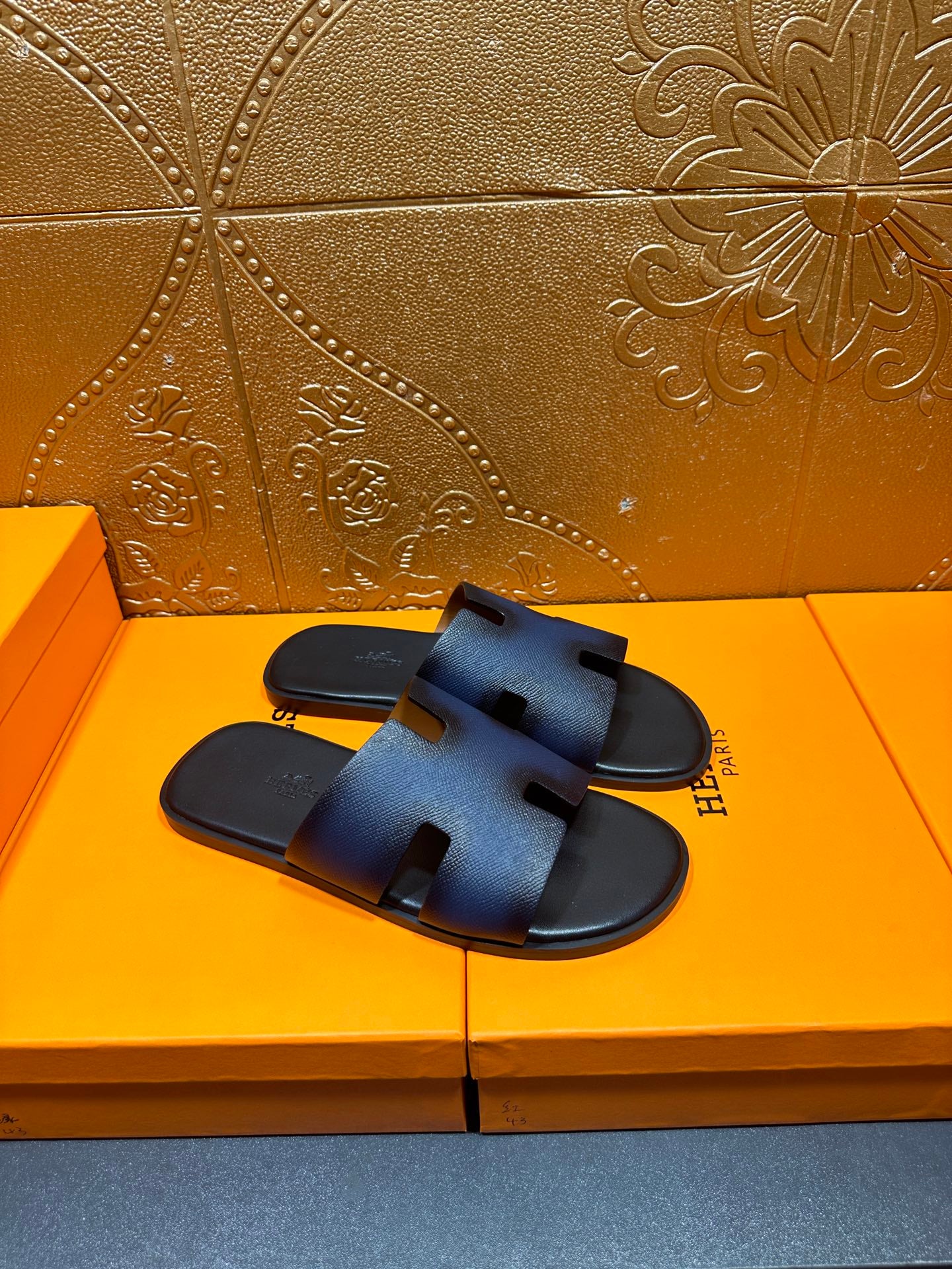 Hermes slide sandals, dark blue leather slides with black footbed and H strap.