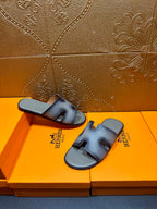 Hermes slide sandals shown from above, light blue leather with front cutout