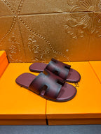 Slide sandals shown from side angle, dark purple leather straps with H buckle