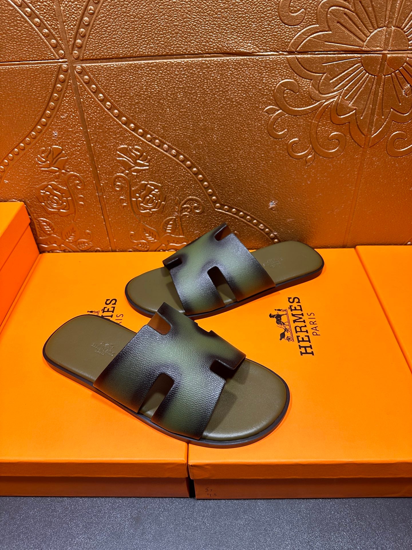 Hermes sandals with blue-green gradient straps, front view on shoebox