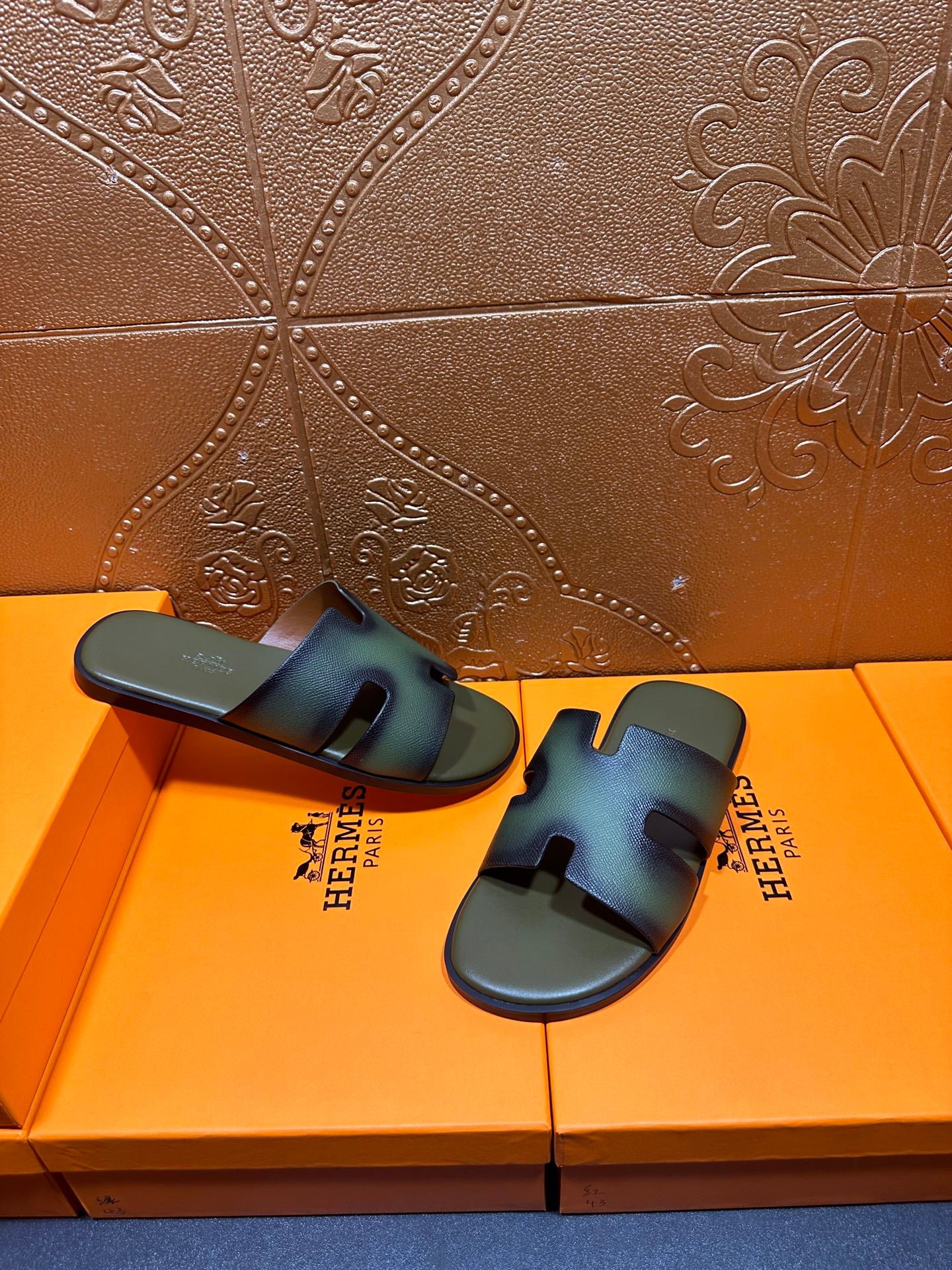 Hermes sandals, blue-green slide with cutout strap design, angled on box