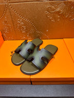 Hermes sandals with open-toe design, blue-green straps, pair on shoebox