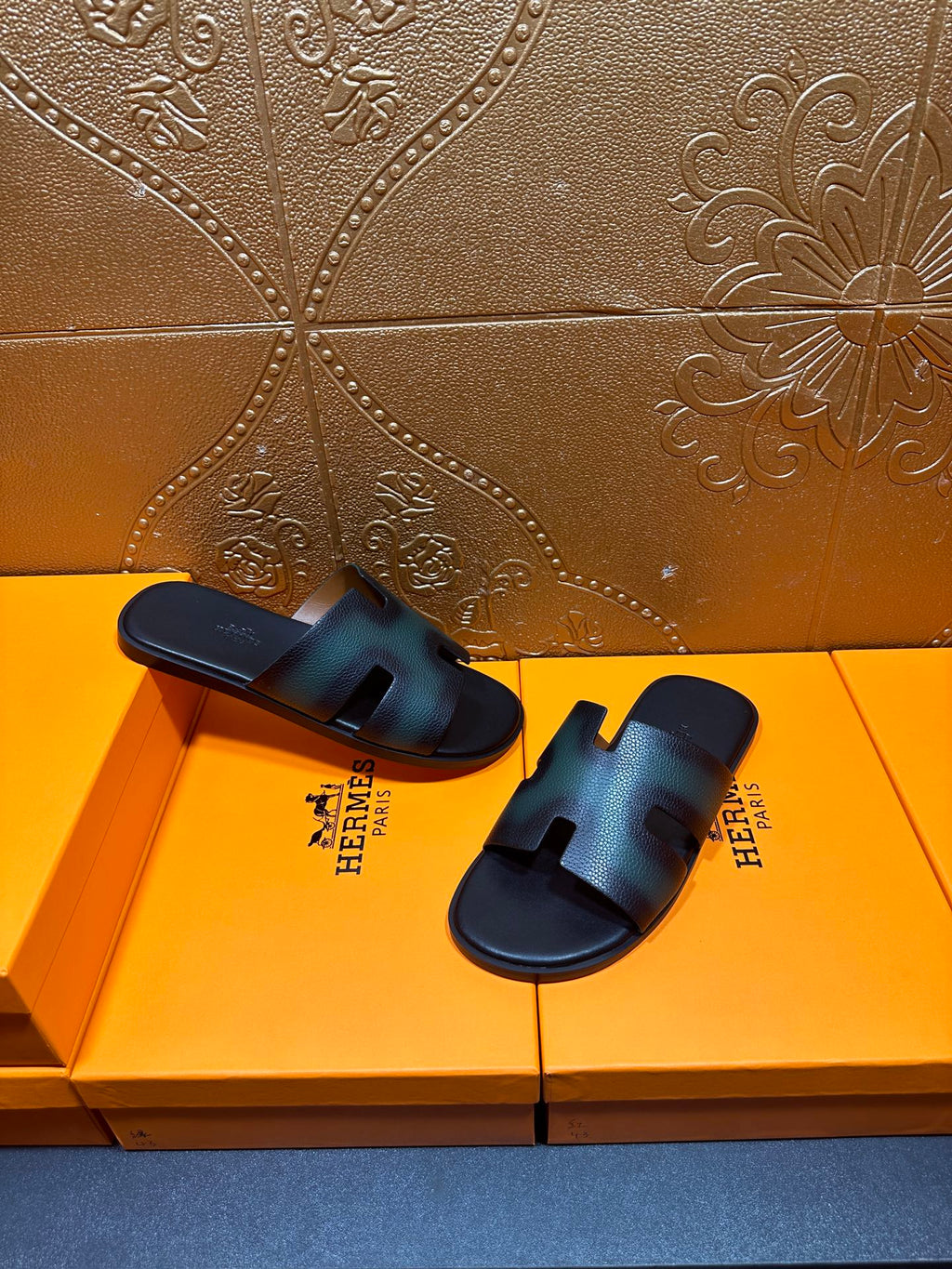Hermes sandals laid side by side, dark teal leather straps with open toe
