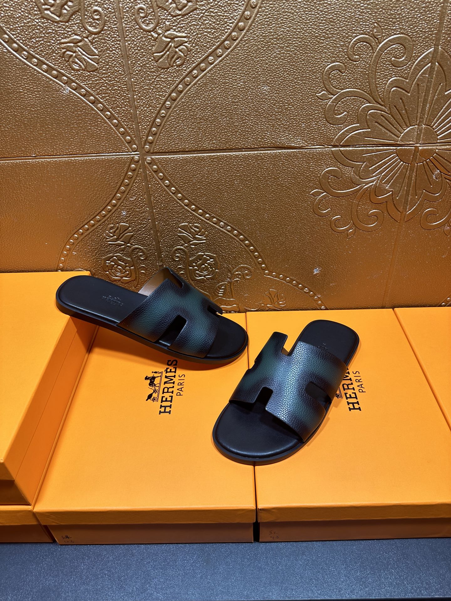 Hermes sandals laid side by side, dark teal leather straps with open toe