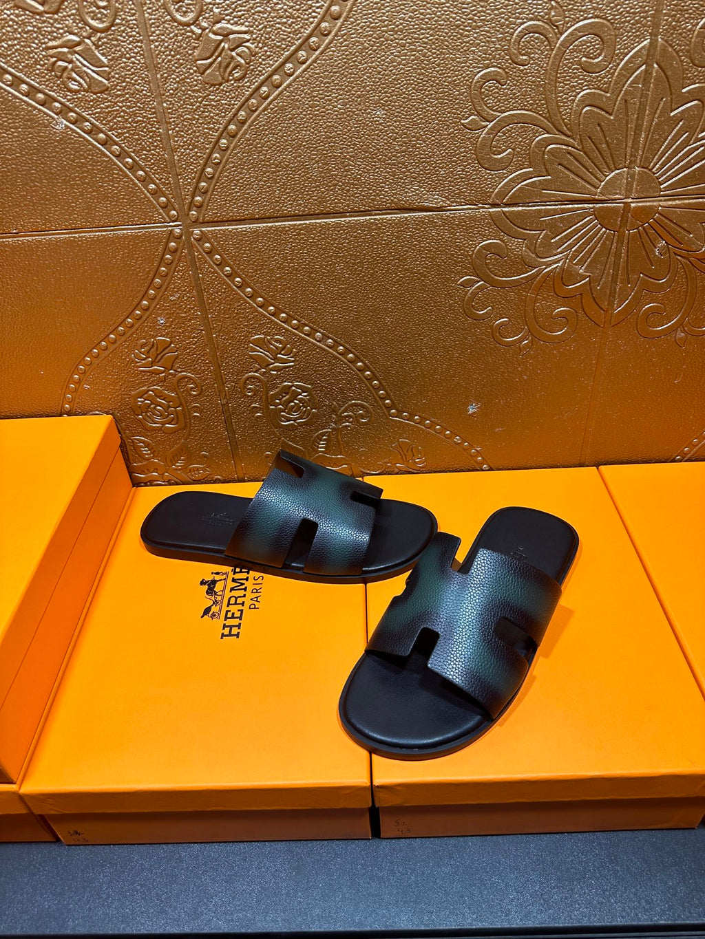 Hermes slide sandals with dark teal leather uppers and open toe, laid on box