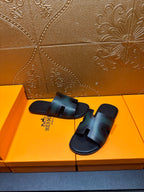 Hermes slide sandals with dark teal leather uppers and open toe, laid on box