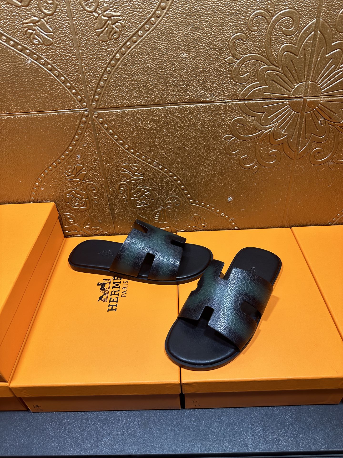 Hermes slide sandals with dark teal leather uppers and open toe, laid on box