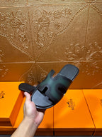 Hermes slide sandal close view, dark teal straps with open toe and contoured sole