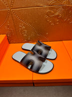 Dark navy leather slide sandals with light blue footbeds, top view, HERMES text.