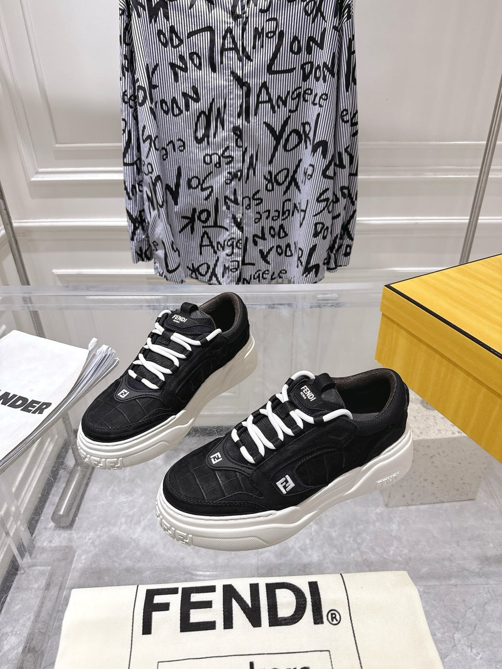 Black Fendi unisex sneakers with white laces and thick sole, on display