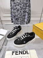Black Fendi unisex sneakers with white laces and thick sole, on display