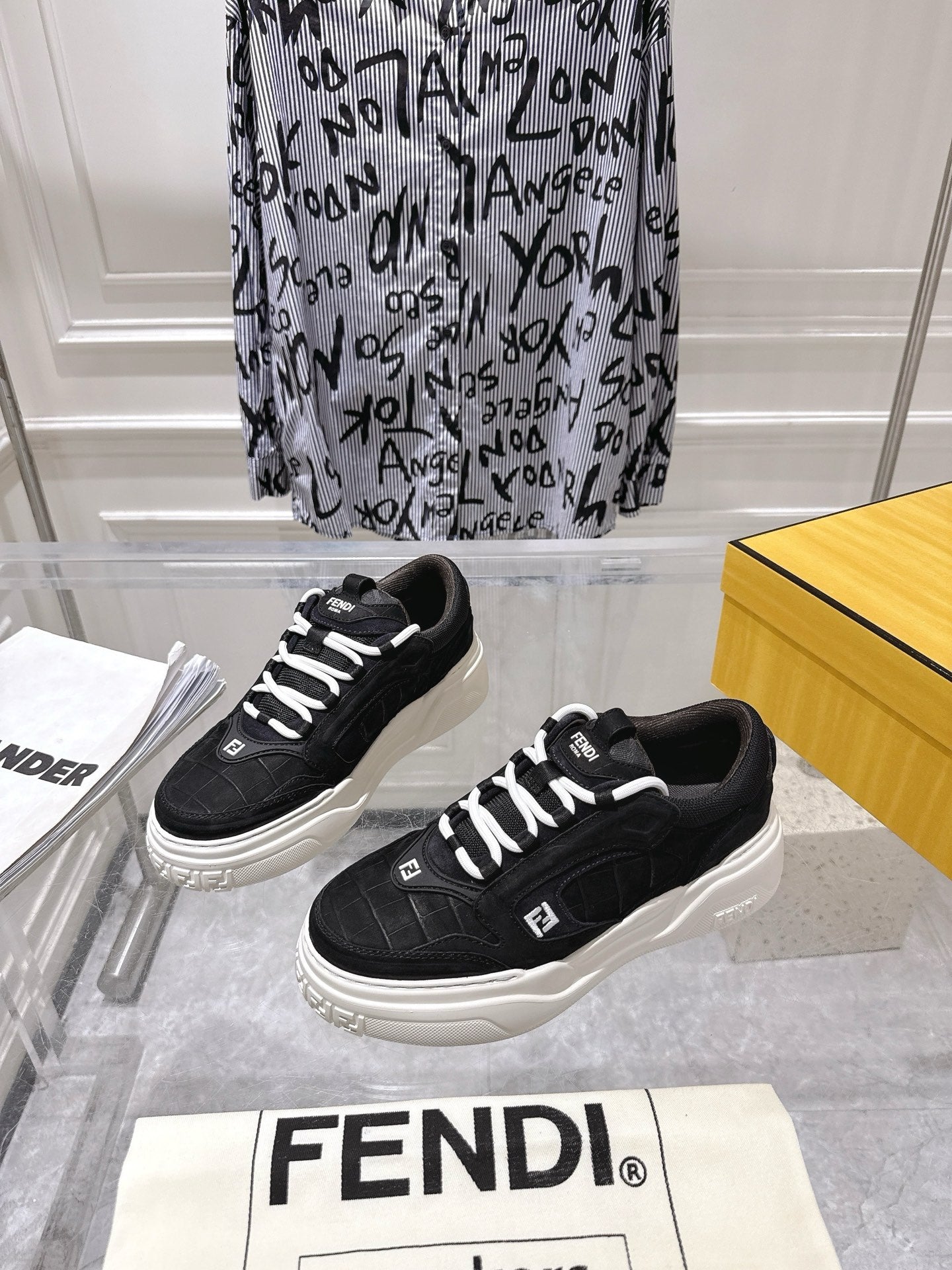 Black Fendi unisex sneakers with white laces and thick sole, on display