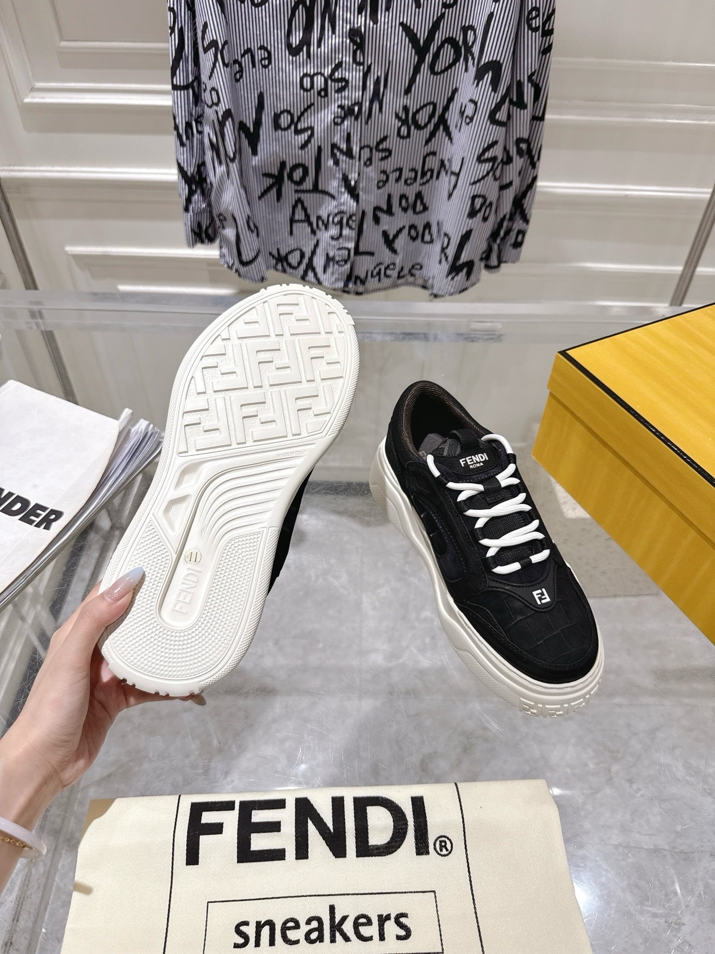 Black Fendi unisex sneakers with white laces, outsole view with tread and logo