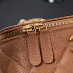 Close-up of tan quilted Chanel bag zipper and leather pull tabs
