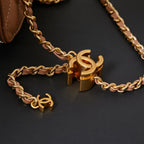 Close-up of gold chain strap with Chanel CC clasp on tan bag