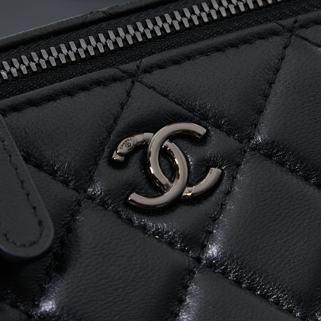 Chanel quilted leather bag close-up of metal CC turn-lock detail, black
