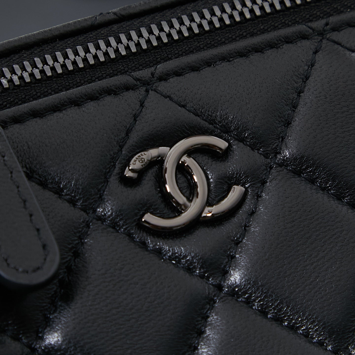 Chanel quilted leather bag close-up of metal CC turn-lock detail, black