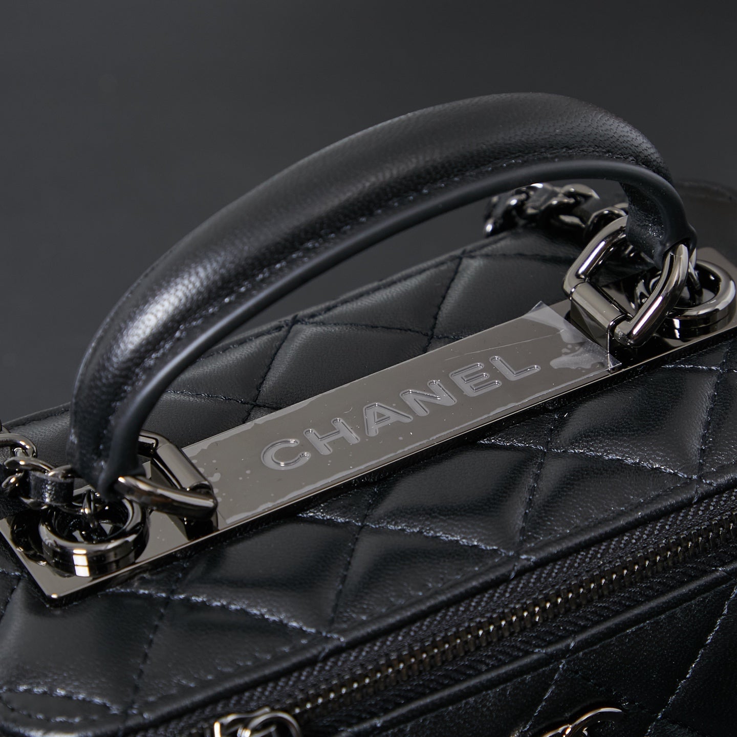Chanel quilted leather bag detail with metal chain and embossed CHANEL strap