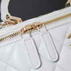 Gold zipper hardware and leather trim on white quilted bag