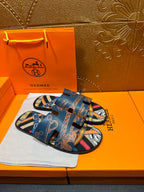 Blue Hermes logo slide sandals with patterned straps and open toe, side view.