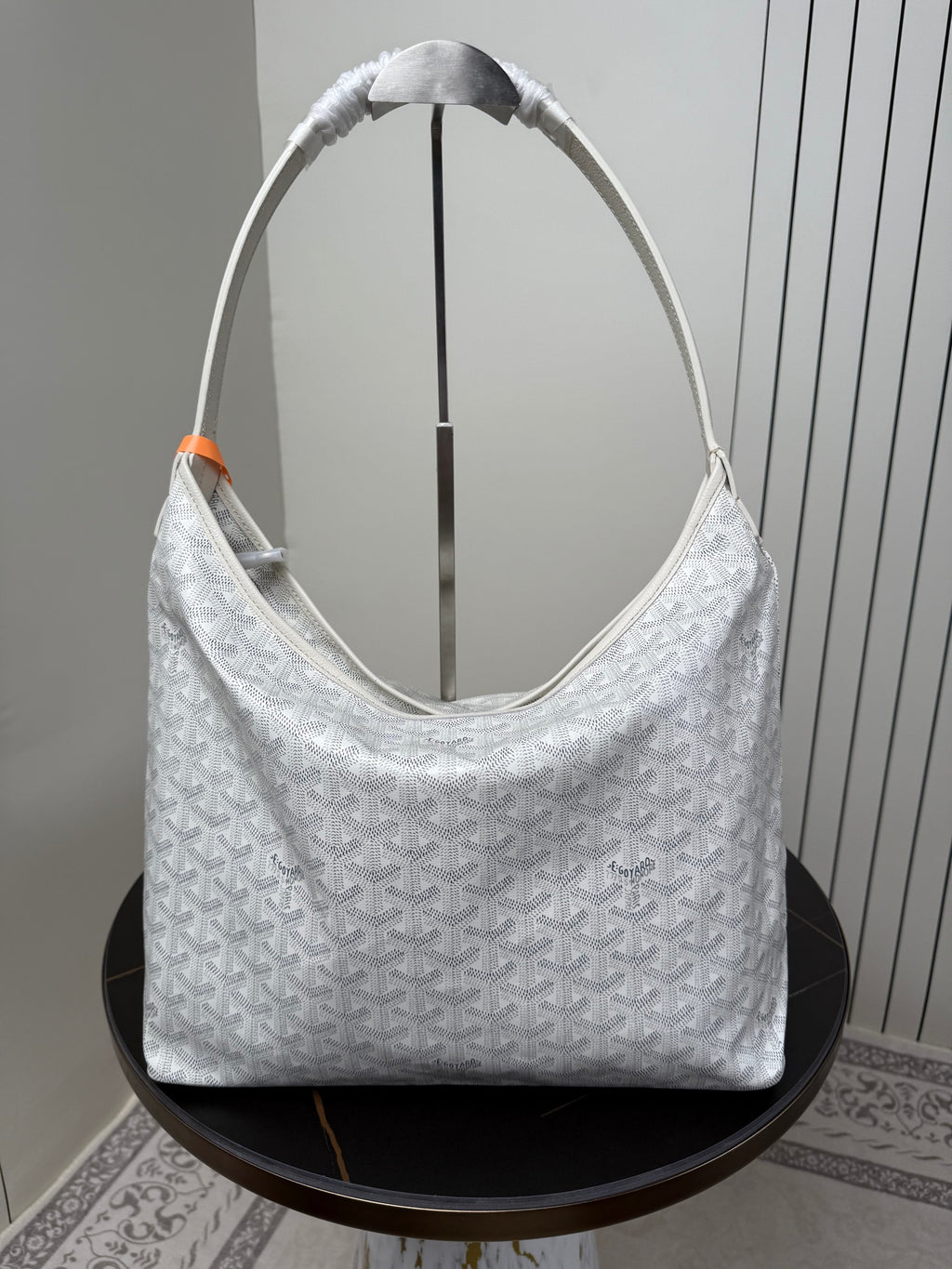 Goyard white hobo bag with woven top handles and textured monogram pattern.