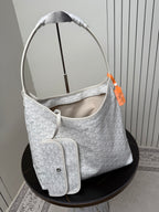 Goyard white hobo bag with curved handles, monogram texture, and matching pouch.
