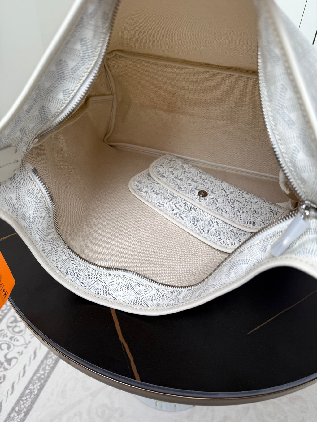 Goyard white hobo bag interior with lining and zip pocket in monogram fabric.